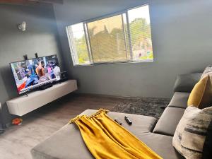a living room with a couch and a flat screen tv at Number 87 in East London