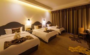 ein Hotelzimmer mit 2 Betten mit Dekorationen darauf in der Unterkunft 慧兰酒店bodhi hotel 