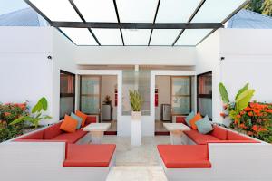 un patio con muebles rojos y almohadas de color naranja en Bali Ginger Suites & Villa, en Seminyak