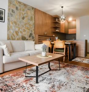 a living room with a couch and a table at Kraljev trg - lux apartman in Zlatibor