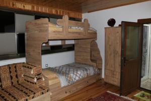 Cette chambre comprend un grand lit superposé en bois. dans l'établissement Uludağ ve Bursa manzaralı Lüks Dağ Evi, à Yıldırım