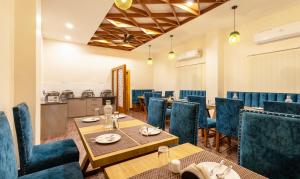 uma sala de jantar com mesas e cadeiras e uma cozinha em Treebo Trend Royal Palace, Zoo Road em Dispur