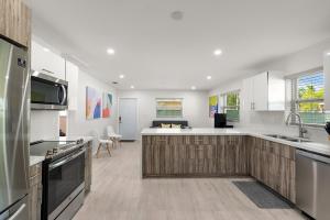 - une cuisine avec des murs blancs et des placards en bois dans l'établissement Gated 2Bd 1Bth Design Dist 10-Min to Beach - 5037, à Miami