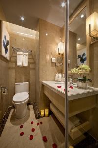 baño con aseo y lavamanos con rosas en el suelo en 石家庄诺华廷酒店 Novlion hotel en Shijiazhuang