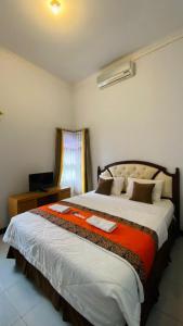 a bedroom with a large bed in a room at Omah Najwa by Sampai Coliving in Kejayan