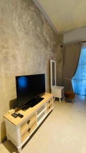 a living room with a flat screen tv on a cabinet at Omah Najwa by Sampai Coliving in Kejayan +15 photos