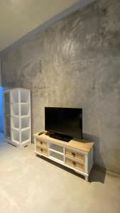 a living room with a tv and a white cabinet at Omah Najwa by Sampai Coliving in Kejayan