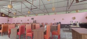 une salle à manger avec des tables en bois et des chaises orange dans l'établissement Joye Grand Hotel, à Havelock Island