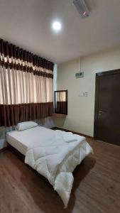 a bedroom with a large white bed and a window at Hotel Bestari in Malacca