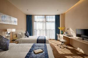 a hotel room with two beds and a flat screen tv at 石家庄诺华廷酒店 Novlion hotel in Shijiazhuang