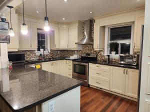 a kitchen with white cabinets and granite counter tops at Toronto Uptown 1 in Toronto