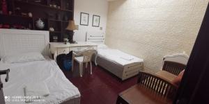 a bedroom with two beds and a desk and a chair at 回家民宿 in Dubai