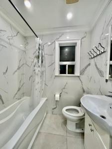 La salle de bains blanche est pourvue de toilettes et d'un lavabo. dans l'établissement Toronto Uptown 1, à Toronto