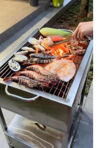 a person is cooking food on a grill at Oceanami Villa Long Hải - Vũng Tàu in Long Hai