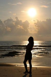 kobieta stojąca na plaży o zachodzie słońca w obiekcie Oceanami Villa Long Hải - Vũng Tàu w mieście Long Hai