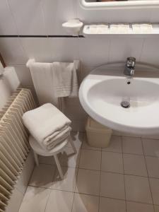 Baño blanco con lavabo y aseo en Garnì Bonsai, en Pinzolo
