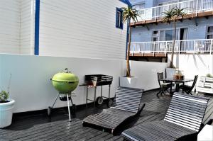 a patio with two chairs and a green bowl on a balcony at Point Village Guest House in Mossel Bay