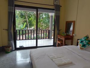 - une chambre avec un lit et une grande fenêtre dans l'établissement Khamphan Guesthouse, à Nongkhiaw