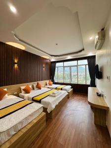 1 Schlafzimmer mit 3 Betten und einem großen Fenster in der Unterkunft Minh Hoang Hotel & Homestay in Cao Bằng