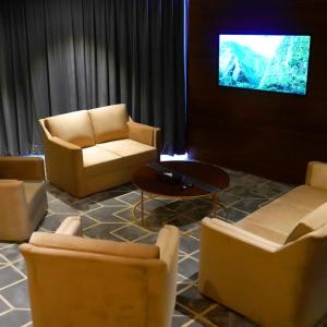 ein Wohnzimmer mit Sofas und einem Flachbild-TV in der Unterkunft Indigo Heights Hotel & Suites in Lahore