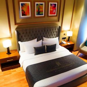 a hotel room with a large bed and two lamps at Indigo Heights Hotel & Suites in Lahore