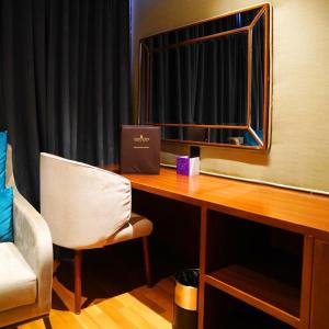 a room with a desk with a mirror and a chair at Indigo Heights Hotel & Suites in Lahore