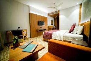 Cette chambre comprend un lit et un bureau. dans l'établissement Hotel Surya, Kaiser Palace, à Varanasi
