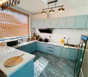 a kitchen with blue cabinets and a counter top at Creek Tang B&B in Huairou