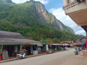 a street in a town with a mountain in the background at Khamphan Guesthouse in Nongkhiaw
