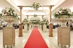 a wedding aisle with a red carpet and vases at Hotel 678 Cawang powered by Cocotel in Jakarta