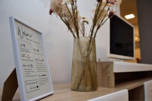 a vase with flowers in it next to a sign at Heart of the City - 75sqm Suite in Skopje