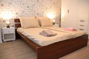 a bedroom with a bed with two towels on it at Heart of the City - 75sqm Suite in Skopje