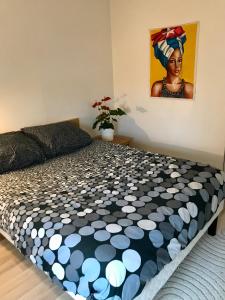 a bed in a room with a painting on the wall at cosy & pratique in La Plaine-Saint-Denis