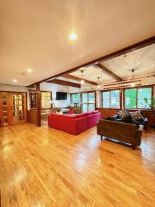 uma grande sala de estar com dois sofás vermelhos em Moment Chalet Hakuba em Hakuba