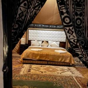 a bedroom with a king sized bed in a room at Family Luxury Glamping in Merzouga