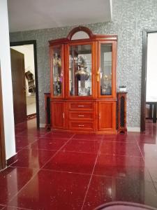 a wooden cabinet in a room with a red floor at 回家民宿 in Dubai