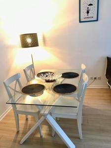 a glass table with two chairs and a lamp at cosy & pratique in La Plaine-Saint-Denis