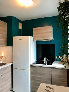 a kitchen with a white refrigerator and a sink at cosy & pratique in La Plaine-Saint-Denis