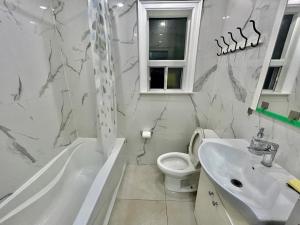 uma casa de banho branca com um lavatório e um WC em Toronto Uptown 2 - Bus Accessible to Downtown em Toronto