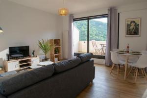 een woonkamer met een bank en een tafel bij Ville & Nature, Belle Vue avec Piscine in Chamalières