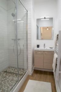 een badkamer met een glazen douche en een wastafel bij Ville & Nature, Belle Vue avec Piscine in Chamalières