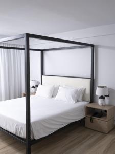 - une chambre avec un lit à baldaquin noir et des oreillers blancs dans l'établissement Hersonissos Palace, à Chersónissos