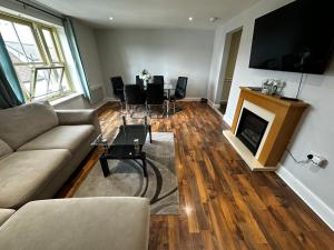 a living room with a couch and a table and a fireplace at Two Bedroom Flat Town Centre Colchester in Colchester