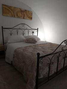 a bedroom with a black bed with a white comforter at Dimora Margherita in Matera