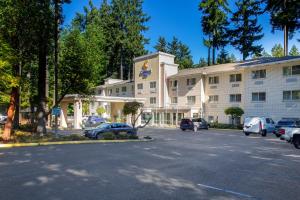 a large white building with cars parked in a parking lot at Comfort Inn Lacey - Olympia in Lacey