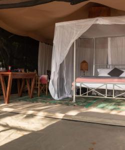 ein Schlafzimmer mit einem Bett unter einem Zelt in der Unterkunft Nje Bush Camp in Kwangwazi
