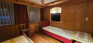 a small room with a bed and a tv at Hotel-Garni Pramstraller in Mayrhofen