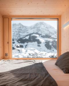 a bedroom with a view of a snow covered mountain at Revier Mountain Lodge Adelboden in Adelboden