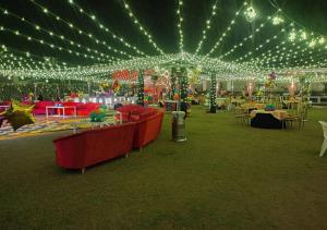 ein großes Zelt mit Beleuchtung, Tischen und Stühlen in der Unterkunft Alwar Vanyaevilas in Alwar