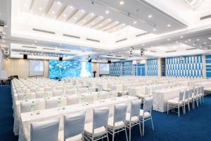 un salón de banquetes con mesas y sillas blancas en Carmelina Beach Resort Ho Tram en Ho Tram